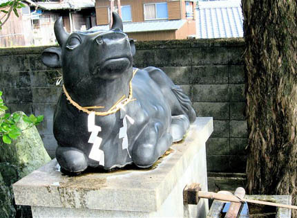 中言神社の黒牛。台座横の竹筒（写真右下）から名水がわき出ている。